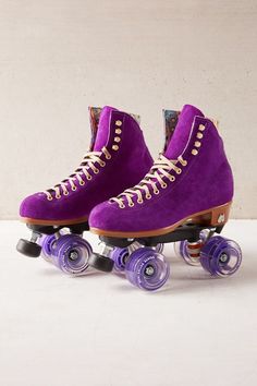 two purple roller skates with white laces on the bottom and one has blue wheels