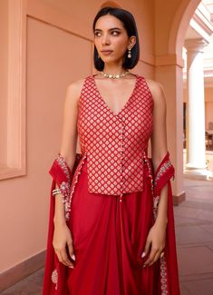 Elevate your wardrobe with this exquisite Red Embroidered Skirt Set, crafted from luxurious chanderi jacquard. The vibrant red blouse, adorned with intricate embroidery, exudes sophistication and style, making it perfect for festive occasions and special gatherings. Paired with a flowing skirt that drapes elegantly, this ensemble creates a flattering silhouette, blending traditional craftsmanship with contemporary design for a look that is both timeless and captivating. Style it with a layered c Red Cotton Silk Sharara With Cutdana, Red Cotton Silk Sharara With Cutdana Details, Red Cotton Silk Sharara With Traditional Drape, Red Semi-stitched Cotton Silk Sharara, Red Traditional Cotton Silk Sharara, Traditional Red Cotton Silk Sharara, Red Cotton Silk Sharara For Diwali, Bollywood Style Red Cotton Silk Sharara, Elegant Brocade Pre-draped Saree For Designer Wear