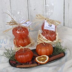 two bags of dried tomatoes on a tray with cinnamon sticks and oranges next to them