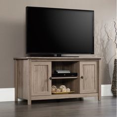 a flat screen tv sitting on top of a wooden entertainment center