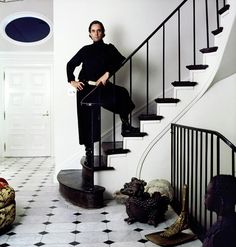 a man sitting on top of a stair case next to a black and white floor