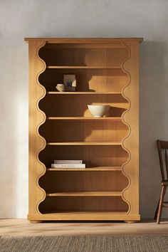 a wooden bookcase sitting on top of a carpeted floor