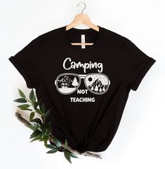 "Camping Not Teaching Teacher Shirt, Teacher Summer Shirt, Camping Teacher Gift, Schools Out Shirt, Teacher Retirement Shirt, Retired Teacher FIND MORE OF OUR SHIRTS HERE www.etsy.com/shop/LaShopatigus 🛒 HOW TO ORDER 🛒 1️⃣ Check photos for sizing and color options 2️⃣ Select your shirt size, color and quantity 3️⃣ Click \"Add to cart\"  4️⃣ Click \"Proceed to check out\" to place order 📏 SHIRT SIZING & MATERIAL📏 - Bella + Canvas Brand Shirt - Unisex Adult Sizing - See Size Chart Image for Proper Sizing - Rolled sleeves are for styling purposes only - Props used in photos are not included with the purchase. ✈️  PROCESSING & SHIPPING ✈️  - Processing Time: 1-5 business days - Standard Shipping: 1-7 business days (after processing time) ✨ CUSTOMER SATISFACTION ✨ We know you will love your Black Letter Print Tops For Camping, Black Cotton Camp Shirt With Letter Print, Black Cotton Tops For Camping, Black Cotton Top For Camping, Koala Shirt, Retirement Shirt, Retired Teacher, Teacher Summer, Retirement Shirts