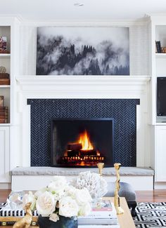 a living room filled with furniture and a fire place in the middle of a fireplace