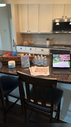 a laptop computer sitting on top of a kitchen counter