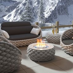 a fire pit sitting on top of a patio next to two chairs and a table