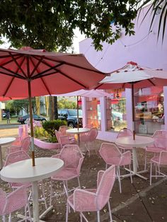 tables and chairs with umbrellas on the sidewalk