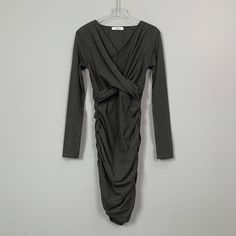 This dress features a V-neckline, pleating to create a shaping effect, and concealment of the tummy. The skirting is designed to fit closely to the body, adding a touch of elegance and sophistication to the overall look. The dress is a perfect choice for any occasion, whether it's a formal event or a night out on the town. The pleating also adds a touch of flexibility to the dress, allowing it to fit comfortably and move easilySeason: Spring, Summer, AutumnSize: FColor: Dark Grey, Black, Burgund Chic Fitted Pleated V-neck Dress, Ruched V-neck Wrap Dress For Night Out, Fitted V-neck Dress With Folds, Elegant V-neck Midi Dress With Folds, Flattering Ruched V-neck Midi Dress, Chic Stretch Dress With Surplice Neckline, V-neck Mini Dress With Pleated Waist For Evening, V-neck Ruched Dress With Surplice Neckline For Night Out, V-neck Dresses With Fitted Waist For Date Night