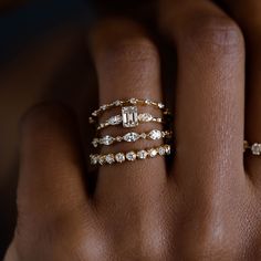 a woman's hand with three different rings on her left and the other one is wearing