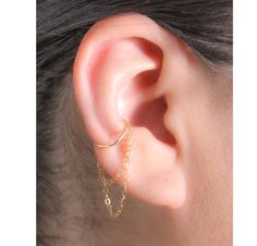 "This Simple and eye-catching Hoop Earring with Double Chain is very comfy, perfect for everyday wear and can be worn alone or combined with other earrings and cuffs. * Your choice of materials is: Sterling Silver, Rose Gold Filled or Gold Filled. Please choose from the drop-down menu. * Measurements: Conch Hoop inner diameter 10, 11 or 12 mm. Wire Thickness 20 Gauge. * Materials: 14K Gold Filled or .925 Sterling Silver cuff and chain. * Nickel and Lead Free (Hypoallergenic) perfect for sensitive skin. * 100% top quality USA materials.  * Your new jewelry ships nicely wrapped in a jewelry box, ready for gift giving. * No piercing? No problem!! I also have a listing in a \"Cuff\" version:   https://www.etsy.com/listing/827558987/conch-ear-cuff-earring-with-dangling * If you like what you se Earring Cuff Chain, Conch Hoop, Cuff Earring, Conch Earring, Piercing Ideas, Ear Cuff Earings, Conch Piercing, Minimal Jewelry, Ear Piercing