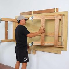 a man is working on a wooden frame