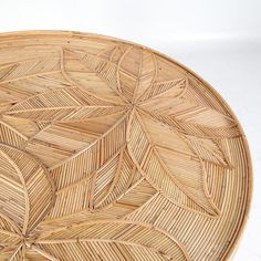 a round wicker tray with leaves on it