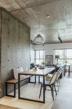 a dining room with concrete walls and flooring in the center, along with two benches on either side