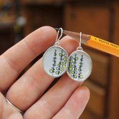 These sterling silver and vitreous enamel dangle earrings have a stylized illustration of a Sweet Pea Vine in blue-grey tones. They measure 1 and 1/4 inches tall with the drop and are 3/4 inches wide.  I ship these First Class Mail with tracking in a gift box. Hand Painted Sterling Silver Earrings For Gift, Hand-painted White Sterling Silver Jewelry, Hand Painted White Sterling Silver Jewelry, Artsy White Everyday Jewelry, Green Hand Painted Sterling Silver Earrings, Everyday Silver Enamel Jewelry, White Hand Painted Drop Earrings, Artistic White Nickel-free Earrings, White Artsy Drop Earrings