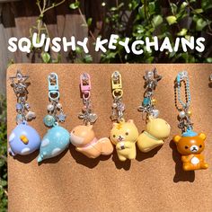 a bunch of keychains that are on a piece of wood with the words squishy ketchans