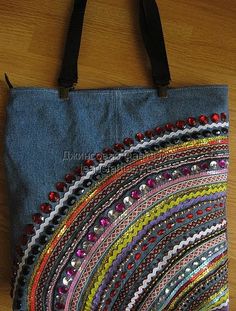 a handbag is decorated with beads and sequins on a wooden table top