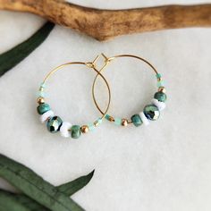 These unique and elegant 18k gold plated hoops are strung with a mix of fire polished Beads, Toho seed glass beads in sea green, real shell beads with a touch of gold and 3mm gold filled beads. They are then finished with tiny Miyuki Japanese seed beads. Easy to wear and would be great for summer and holiday wardrobes! All items come carefully packaged ready for gifting in sparkly tissue paper and a small jute bag with seaside charm. A white logo'd gift box is available for a small additional co Gold Beaded Small Hoop Earrings For Summer, Bohemian 14k Gold-filled Jewelry With Colorful Beads, Gold Beaded Hoop Earrings For The Beach, Gold Hoop Earrings With Tiny Beads For Summer, Beach Hoop Earrings With Tiny Beads, Bohemian Hoop Earrings With Faceted Beads, Gold Hoop Earrings With Colorful Beads For Beach, Gold Beaded Hoop Earrings For Summer, Adjustable Small Hoop Jewelry For Vacation