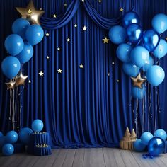 blue and gold balloons are in front of a stage with stars on the curtain backdrop