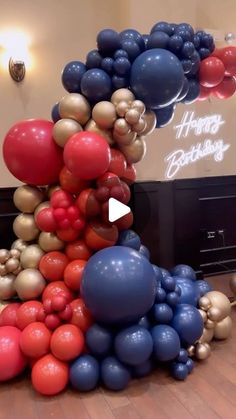 a bunch of balloons that are in the shape of a tower with words happy birthday on it