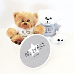 two teddy bears sitting next to each other in a white box with the words oh baby on it