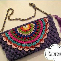 a crocheted purse with a tasselled handle and chain attached to it