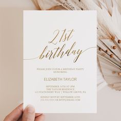 a person holding up a birthday card with the words 21st birthday on it and gold foil lettering