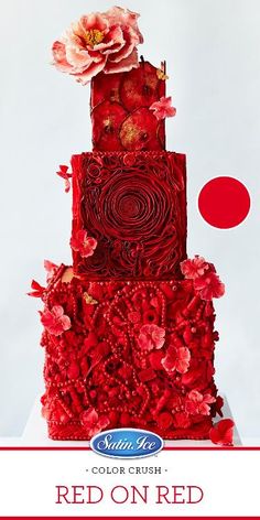 a three tiered red cake with flowers on it's top and bottom layer