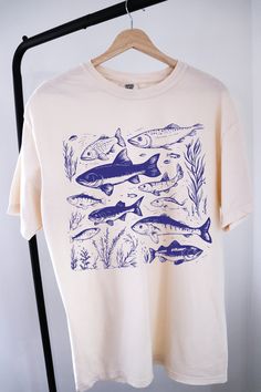 Vintage 90s Tattoo Fish Shirt ⭐ Welcome to K & K Custom Tees! ⭐  - Indulge in pure comfort with our Comfort Colors Shirt. Soft, relaxed, and available in a variety of colors! ⭐SHIRT DETAILS⭐  -High Quality fabric  -100% ring-spun US cotton -Designed and printed in the USA  ⭐ PLEASE NOTE ⭐ -For an oversized look, we suggest to size up 1-2 sizes. These shirts run like standard unisex tees. Please see size chart for a more fitted look!  -Colors may vary based on your monitor or screen display! ⭐CAR Cotton Short Sleeve Top With Fish Print, Short Sleeve Cotton Shirt With Fish Print, Cotton Short Sleeve Shirt With Fish Print, Graphic Tee T-shirt With Fish Print, Graphic Fish Print Short Sleeve T-shirt, Graphic Fish Print T-shirt With Short Sleeves, Graphic Tee With Fish Print Short Sleeve, Short Sleeve Graphic Tee With Fish Print, Short Sleeve Fish Print T-shirt For Fishing