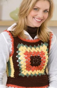 a woman wearing a multicolored crocheted sweater and smiling at the camera