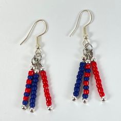 two red, white and blue beaded earrings with silver beads hanging from the ends