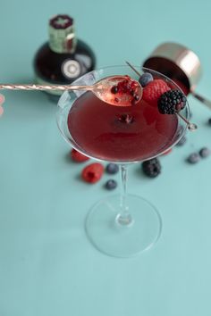 a glass filled with red wine and berries