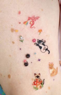 a woman's stomach with various stickers on the side of her body, including cats and other animals