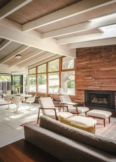 a living room with couches, chairs and a fire place in the middle of it