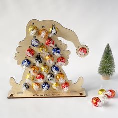 a wooden christmas tree with candy candies in the shape of an elephant and two small trees