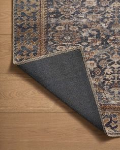 an area rug with blue and brown colors on top of wood flooring next to a wooden