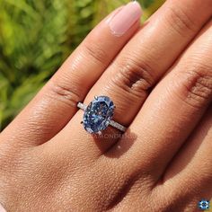 a woman's hand with a ring on it and a blue diamond in the middle