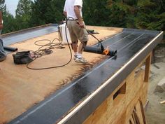 a man using a power washer on top of a roof