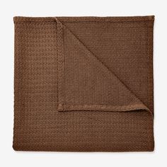 a brown blanket folded on top of a white table