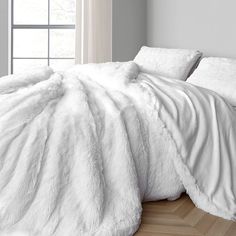 the comforter is white and has fluffy fur on it