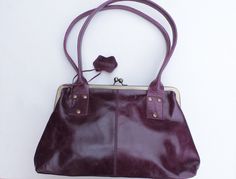 Doris in Purple leather kiss clip, clip frame leather bag with internal compartments, one zipped and another two are open pockets. The lining is waterproof and durable.  This bag has a comfortable rolled shoulder strap.  33x21 and the base is 9,5x32 Strap measures 58cms Inside zip is 18x18 cms and 2 pockets one if which is 13x13 and the smaller open pocket is 8x13 (1 inch = 2.5cms) Leather Shoulder Bag With Hinge Closure, Leather Shoulder Bag With Hinge Closure For Everyday Use, Rectangular Leather Shoulder Bag With Hinge Closure, Everyday Use Satchel Shoulder Bag With Hinge Closure, Leather Hip Bag, Clip Frame, Fanny Bag, Messenger Purse, Leather Roll