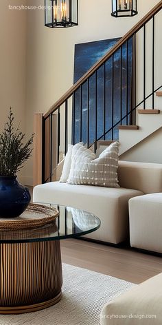 a living room filled with furniture next to a stair case and glass top coffee table