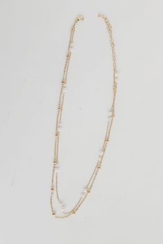 The Brooke Gold Pearl Layered Chain Necklace is the simplest way to make any look even more darling! This trendy necklace features two layers of gold chains with pearls. Style the Brooke Necklace with any outfit to instantly upgrade your look! Gold Plated Layered Pearls Lobster Clasp with Extender Layer 1 | Length 7.5" Layer 2 | Length 7" Extender | Length 3" Gold Pearl Necklace For Layering, Gold Double Strand Pearl Necklace For Layering, Gold Pearl Double Chain Necklace, Gold Double Strand Necklace For Layering, Double Strand Gold Chain Necklace With Pearl Charm, Gold Double Strand Chain Necklace With Pearl Charm, Gold Delicate Chain Layered Necklace With Pearls, Double Strand Pearl Necklace With Chain, White Double Strand Pearl Chain Layered Necklace