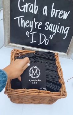 a person holding a sign in front of a basket filled with black cards and papers