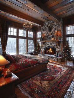 a bedroom decorated for christmas with a fireplace and large bed in the middle, surrounded by windows