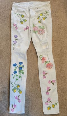 Hand-Painted White Pacsun Jeans Women's Size 31" waist x32" inseam. Floral Design w/hummingbirds. Handmade one of a kind. Created with fabric markers on recycled jeans. Mint condition, snow white. White Jeans Painting, Hand Painted Casual Bottoms For Spring, Painted White Jeans, Hand Painted Straight Leg Jeans For Spring, Spring Hand Painted Straight Leg Jeans, Hand Painted Blue Jeans For Spring, Painted Jeans Flowers, Jeans With Painted Flowers, Hand Painted Flower Jeans