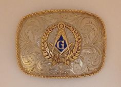 a gold belt buckle with an masonic symbol on it