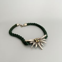 Beautiful vintage Bavarian Edelweiss flower necklace.  Emerald green braided silk cord and metal.  Edelweiss is a favorite motif in Bavarian women's jewelry for a dirndl (Bavarian traditional dress) or costume. ⚜️Good vintage condition with traces of use.  But that's exactly what separates vintage treasures from modern pieces ⚜️More Bavarian vintage: https://www.etsy.com/de/shop/JDVintageDE ⚜️Dimensions: Necklace : 43 cm  Edelweiss : 7.5 cm x 4 cm  Extension chain : 5.5 cm  ⚜️Shipment :  from Ge Folklore Jewelry, Edelweiss Necklace, Edelweiss Jewelry, Edelweiss Flower, Necklace Emerald, Costume Necklaces, Silk Cord, Traditional Dress, Jewelry For Women