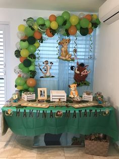 a green table topped with balloons and pictures