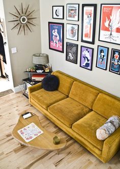 a living room filled with furniture and pictures on the wall