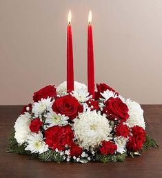 a red candle is lit in a centerpiece with white and red flowers